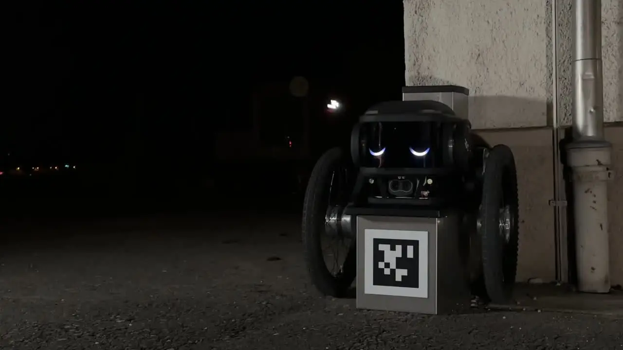 Robot Ascento Guard effectuant une ronde nocturne près d’un point de repère de navigation