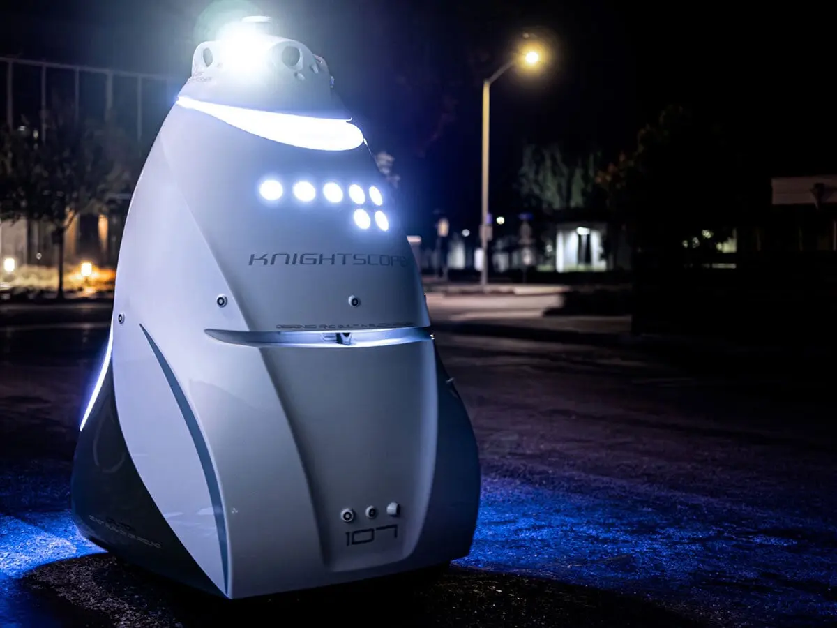 Robot de sécurité Knightscope K5 éclairé pendant une ronde nocturne sur un parking